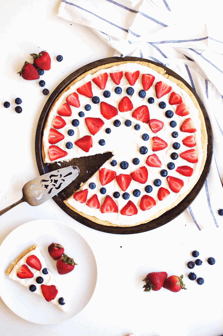This 4th of July berry dessert pizza needs to be at the top of your list of festive foods to make! The combination of juicy, sweet berries and cream cheese icing spread on a sugar cookie crust is absolutely delicious. You’ll definitely be going back for seconds, maybe even thirds! || The Butter Half #easydessert #fruitpizza #summerrecipes #thebutterhalf