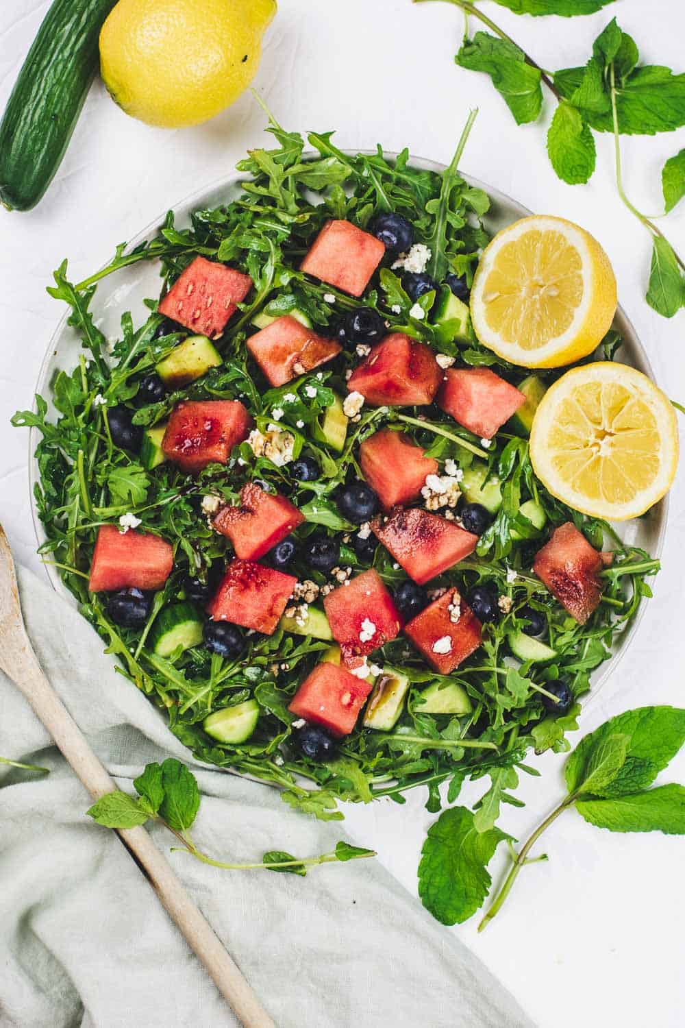 Fresh greens mixed with watermelon and blueberries complement the crunchy cucumbers and bite of Feta Cheese in this Watermelon Arugula Salad. Refreshing, nourishing, and quick, this 10 minutes salad is the perfect way to beat the heat. || The Butter Half #summersalad #saladrecipes #quicksalads #thebutterhalf