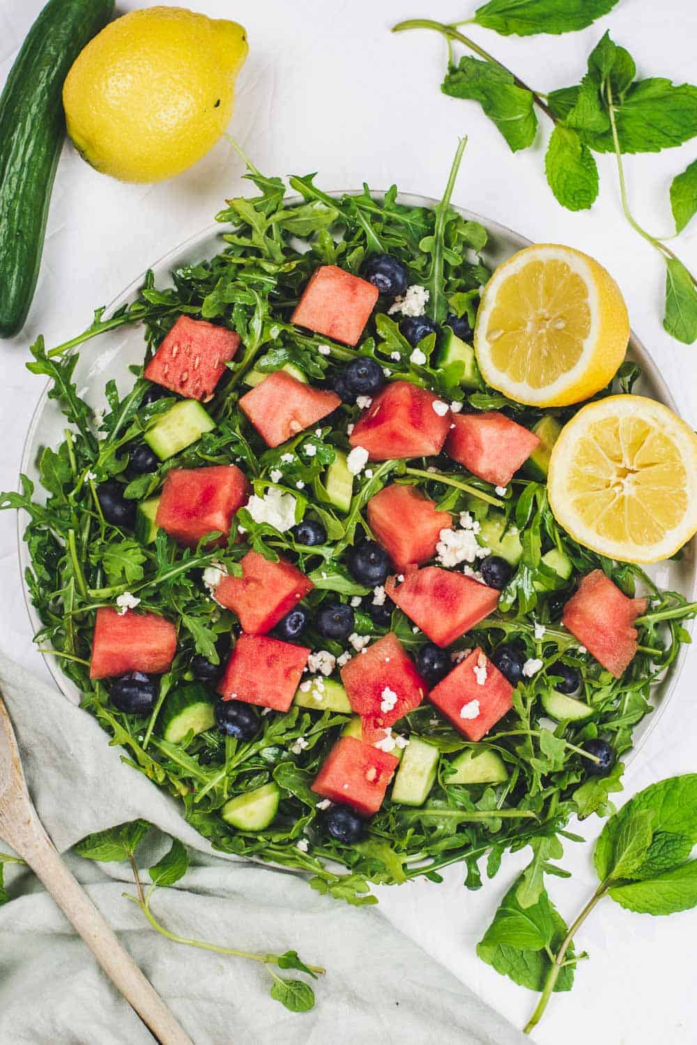Fresh greens mixed with watermelon and blueberries complement the crunchy cucumbers and bite of Feta Cheese in this Watermelon Arugula Salad. Refreshing, nourishing, and quick, this 10 minutes salad is the perfect way to beat the heat. || The Butter Half #summersalad #saladrecipes #quicksalads #thebutterhalf