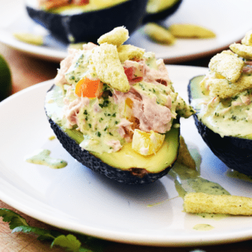Close up of avocado stuffed with tuna and peppers and cilantro lime dressing