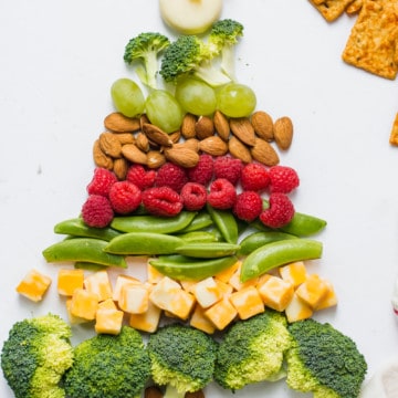 Broccoli, cheese, nuts, grapes, and berries in shape of Christmas tree
