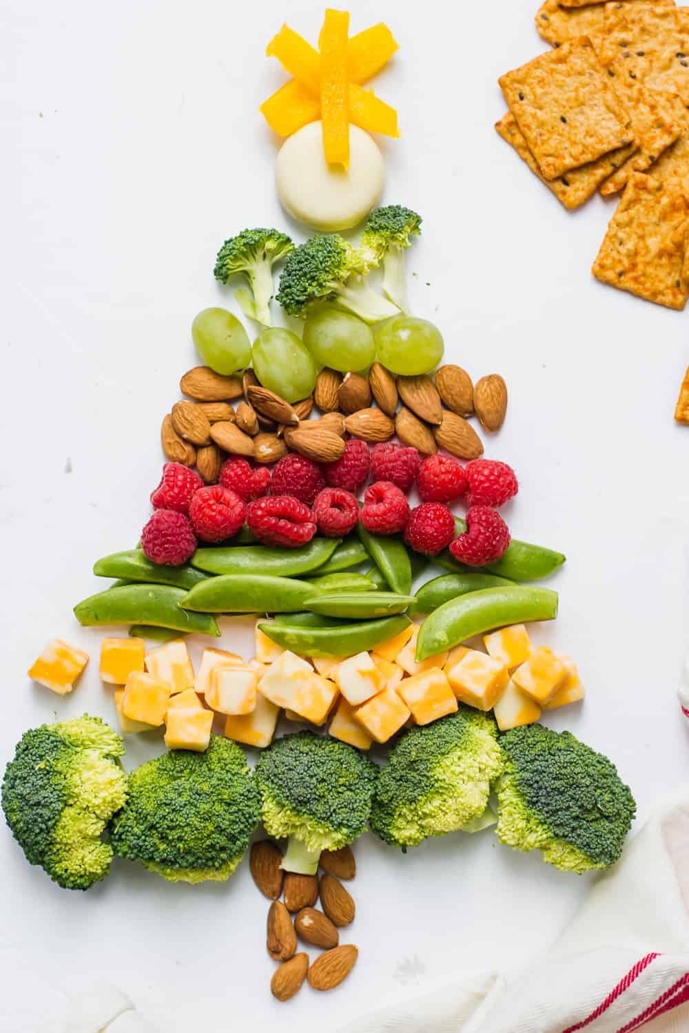 Broccoli, cheese, nuts, grapes, and berries in shape of Christmas tree