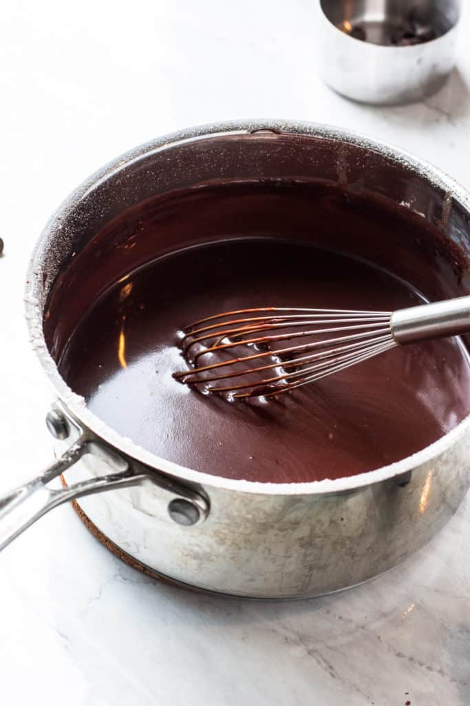 Sauce pan of chocolate sauce with whisk stirring