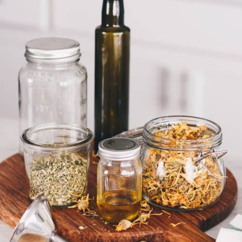 Ingredients for herb infused oils, mason jars, and bottles