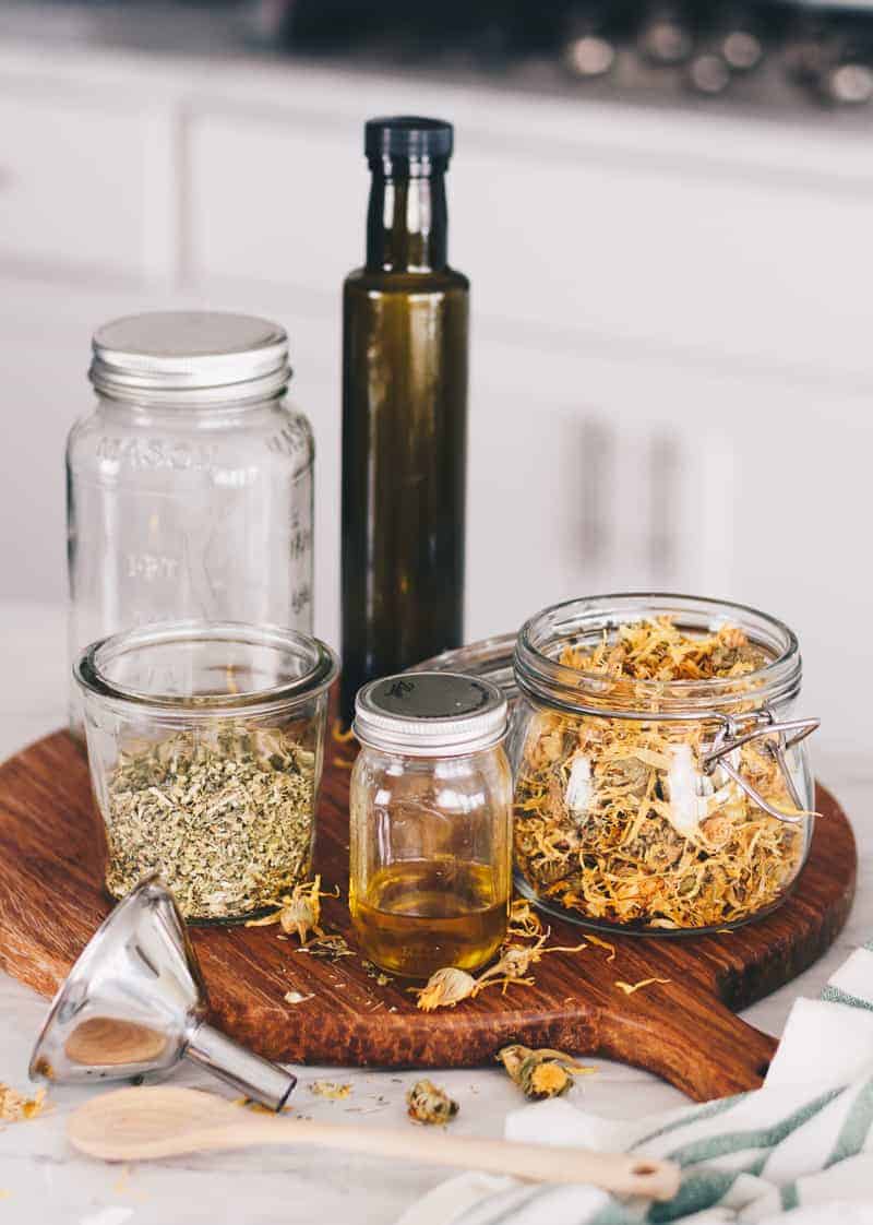Ingredients for herb infused oils, mason jars, and bottles