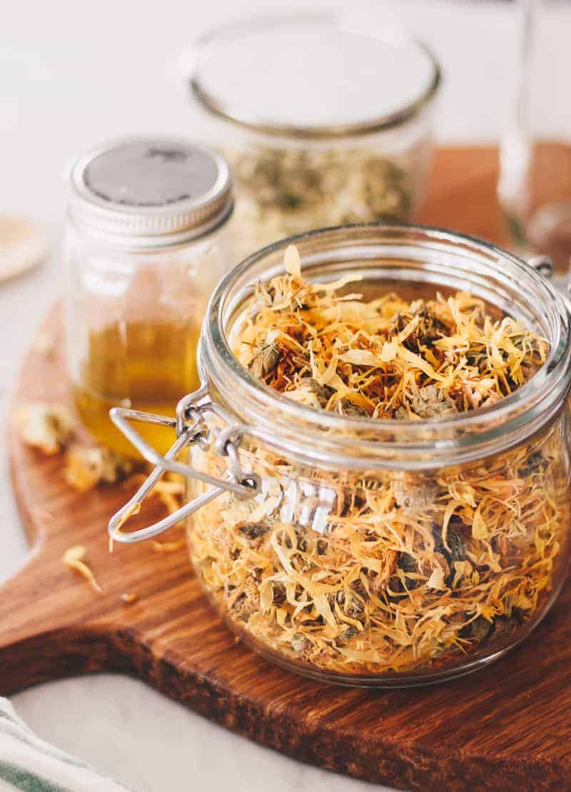 Making Herb Infused Oils is an easy way to enhance your health and cooking. Learn how to make herbal oils with dried herbs and create your own skin care creams, salves, and serums. #herbs #infusedoils #naturalskincare #thebutterhalf