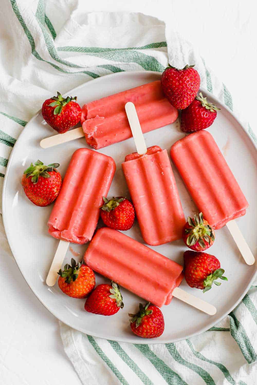 These healthy strawberry popsicles (vegan, paleo) contain only four ingredients and are incredible easy to make with only 5 minutes of prep! || The Butter Half #popsiclerecipe #healthypopsicles #easypopsicles #strawberrypopsicles #veganrecipes #paleorecipes #thebutterhalf