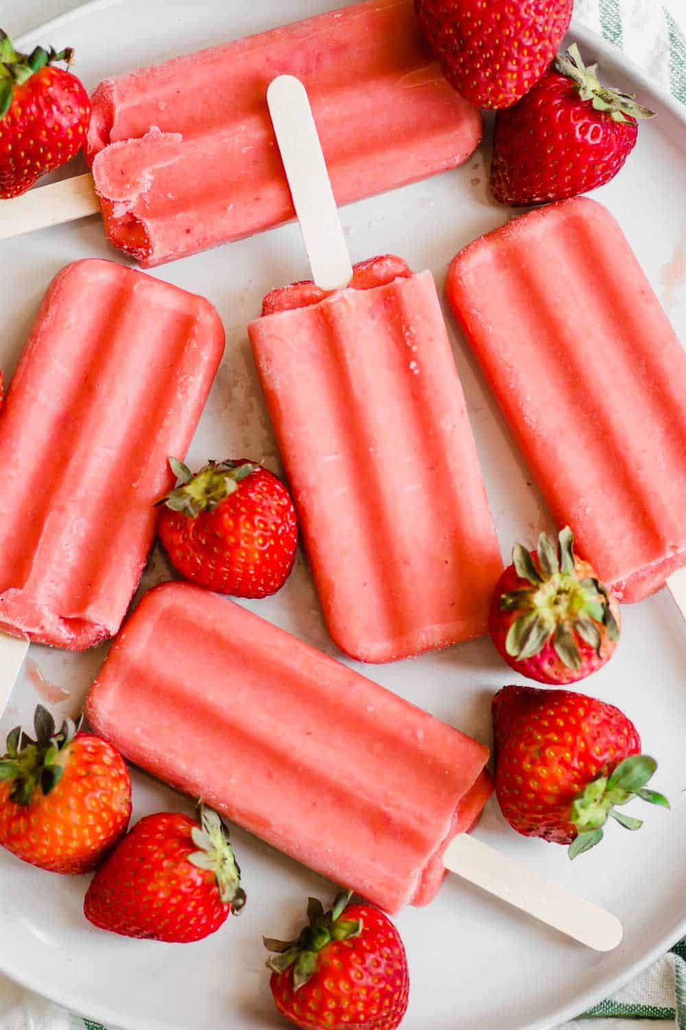 These healthy strawberry popsicles (vegan, paleo) contain only four ingredients and are incredible easy to make with only 5 minutes of prep! || The Butter Half #popsiclerecipe #healthypopsicles #easypopsicles #strawberrypopsicles #veganrecipes #paleorecipes #thebutterhalf