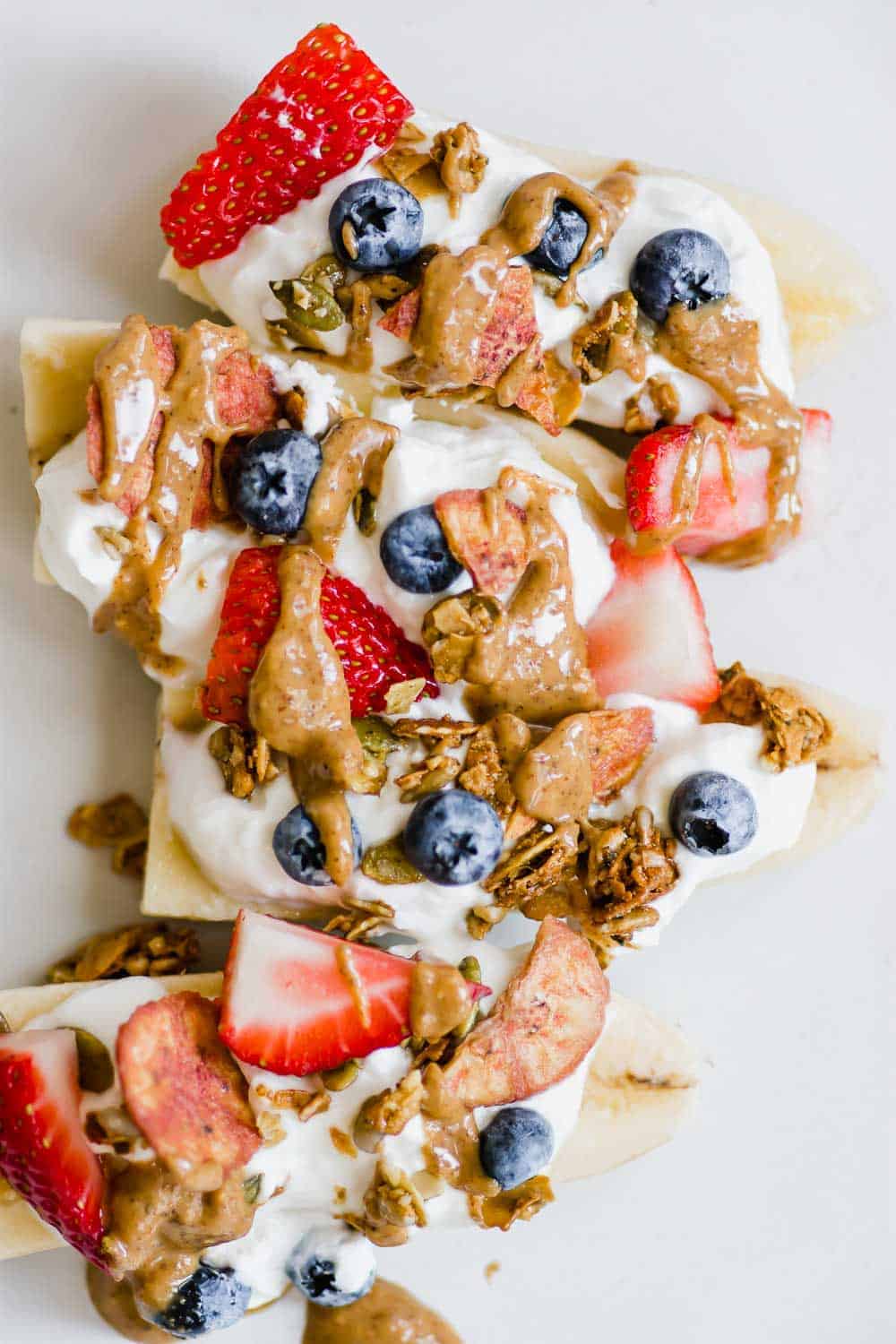 Make this Healthy Banana Split recipe as a better-for-you laternative to the traditiaonal dessert. Serve as an afternoon snack, or as a twist on breakfast. Made with only 5 ingredients, this dish can be made in just 5 minutes. It's a recipe the whole family will love! || The Butter Half #snackrecipes #breakfastrecipes #healthydesserts #bananasplitrecipe #thebutterhalf