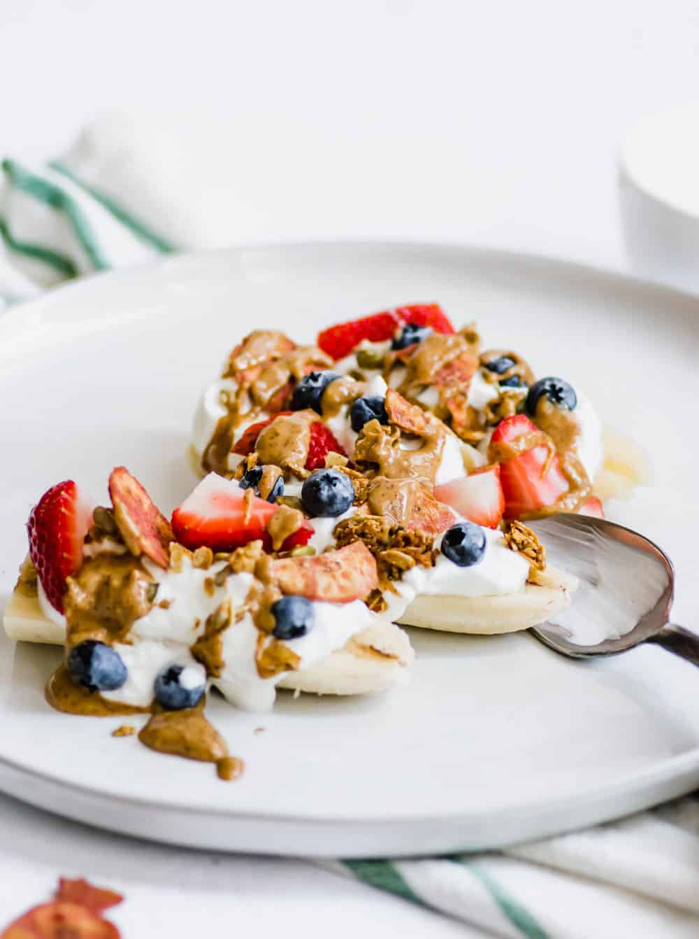 Make this Healthy Banana Split recipe as a better-for-you laternative to the traditiaonal dessert. Serve as an afternoon snack, or as a twist on breakfast. Made with only 5 ingredients, this dish can be made in just 5 minutes. It's a recipe the whole family will love! || The Butter Half #snackrecipes #breakfastrecipes #healthydesserts #bananasplitrecipe #thebutterhalf