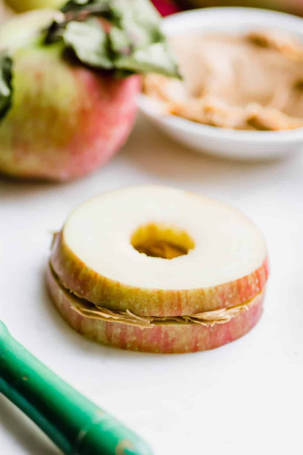 Make this apple and peanut butter sandwich as an easy and healthy snack. Naturally gluten-free and vegan, this can also be made nut-free. Whip this together in under 5 minutes for a snack the whole family will love. || The Butter Half #easysnacks #easysnackidea #healthysnacks #glutenfreesnacks #vegansnacks #quicksnacks #thebutterhalf