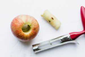 overhead shot of cored apple with apple corer tool on side