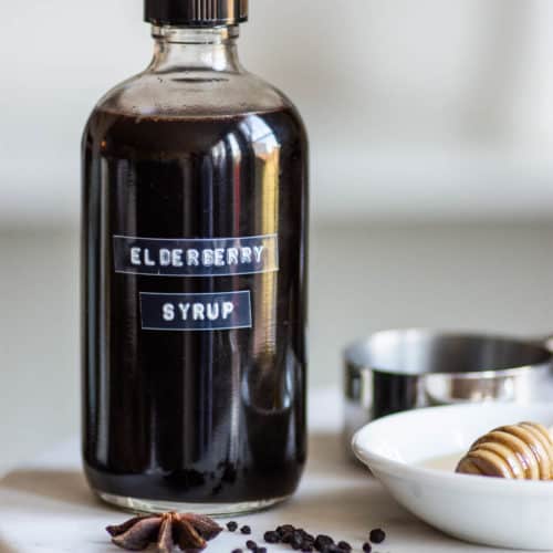 Labeled bottle of elderberry syrup on marble stand