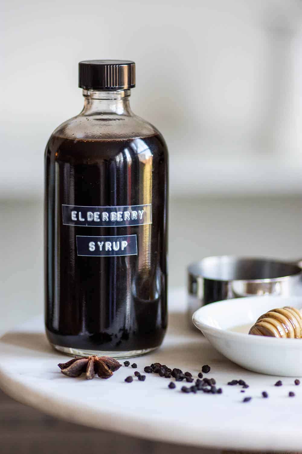 Labeled bottle of elderberry syrup on marble stand