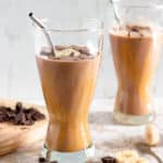 chocolate peanut butter banana smoothie in 2 glasses with a light colored background