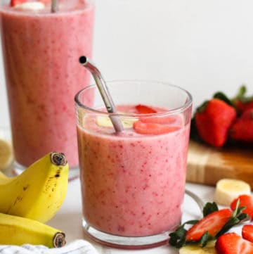 strawberry banana smoothie in a glass with a light colored background