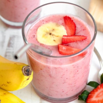 strawberry banana smoothie in a light glass with a light colored background