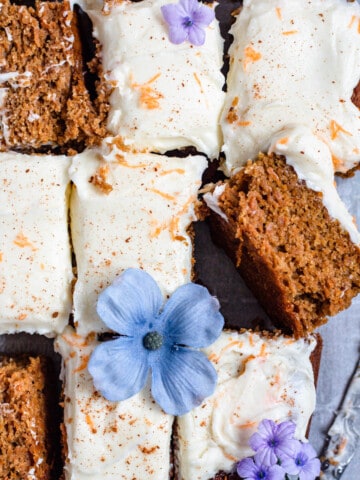 Gluten Free Carrot Cake sliced with lavender flowers topping 3 slices