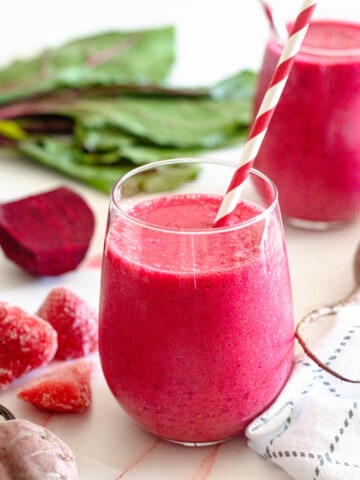 small glass filled with detoxifying beet smoothie recipe with a light colored background