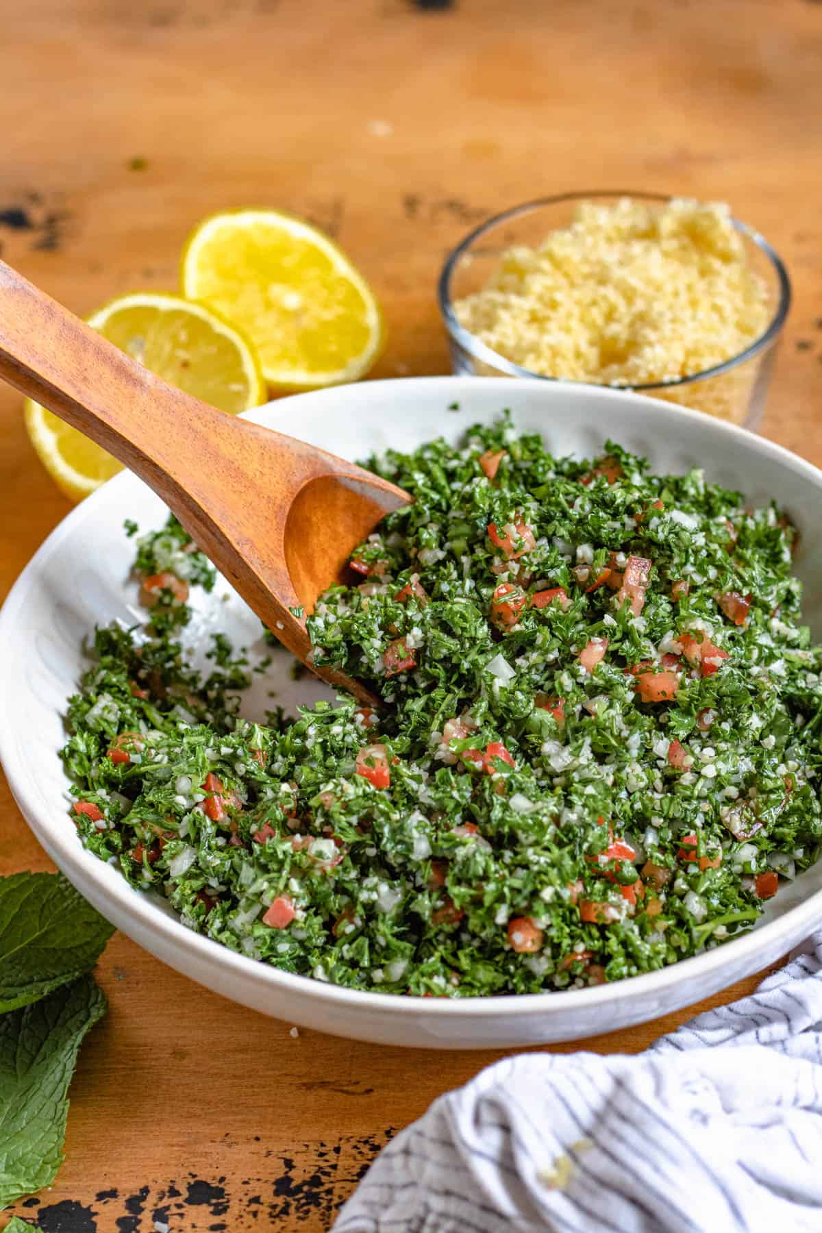 tabouli salad in a round white bowl with a medium colored background