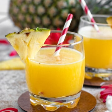 glass filled with homemade pineapple juice with a light colored background