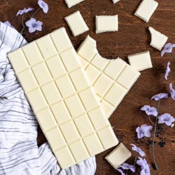 white chocolate broken into pieces on a dark colored background