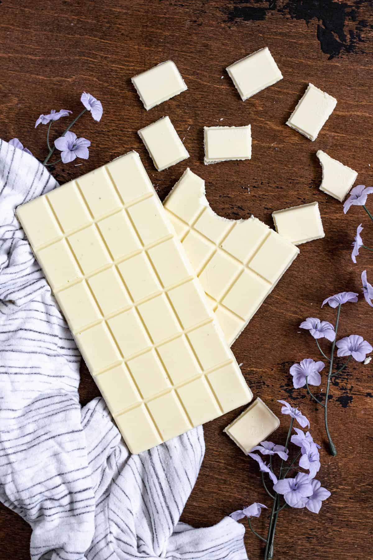 white chocolate broken into pieces on a dark colored background
