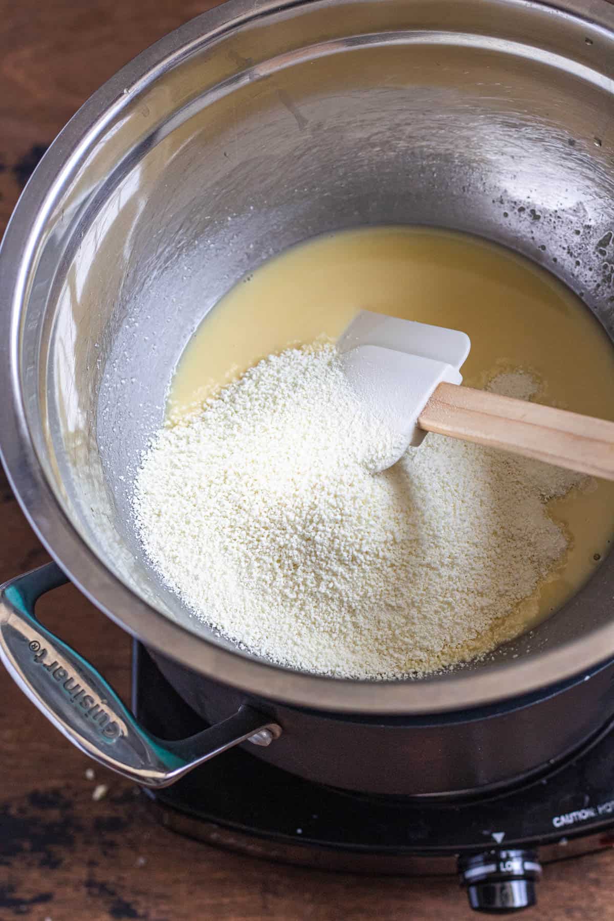 melted cacoa butter and dry milk powder in a medium sized bowl with a spatula in it