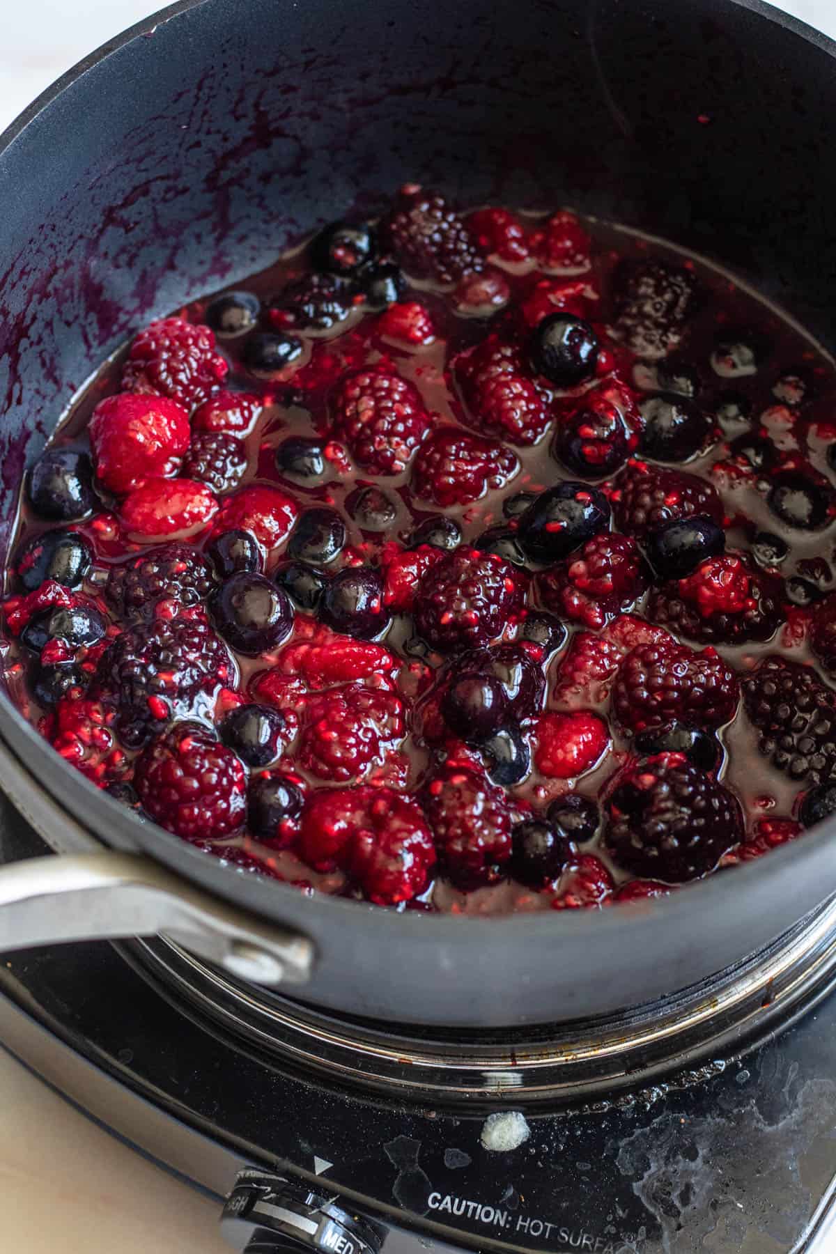 berries, lemon juice, and honey in a pot with some liquid