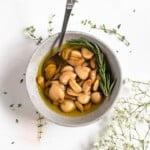 garlic confit in small glass bowl on a light colored background