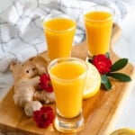 ginger shot recipe in 3 shot glasses with a light colored background