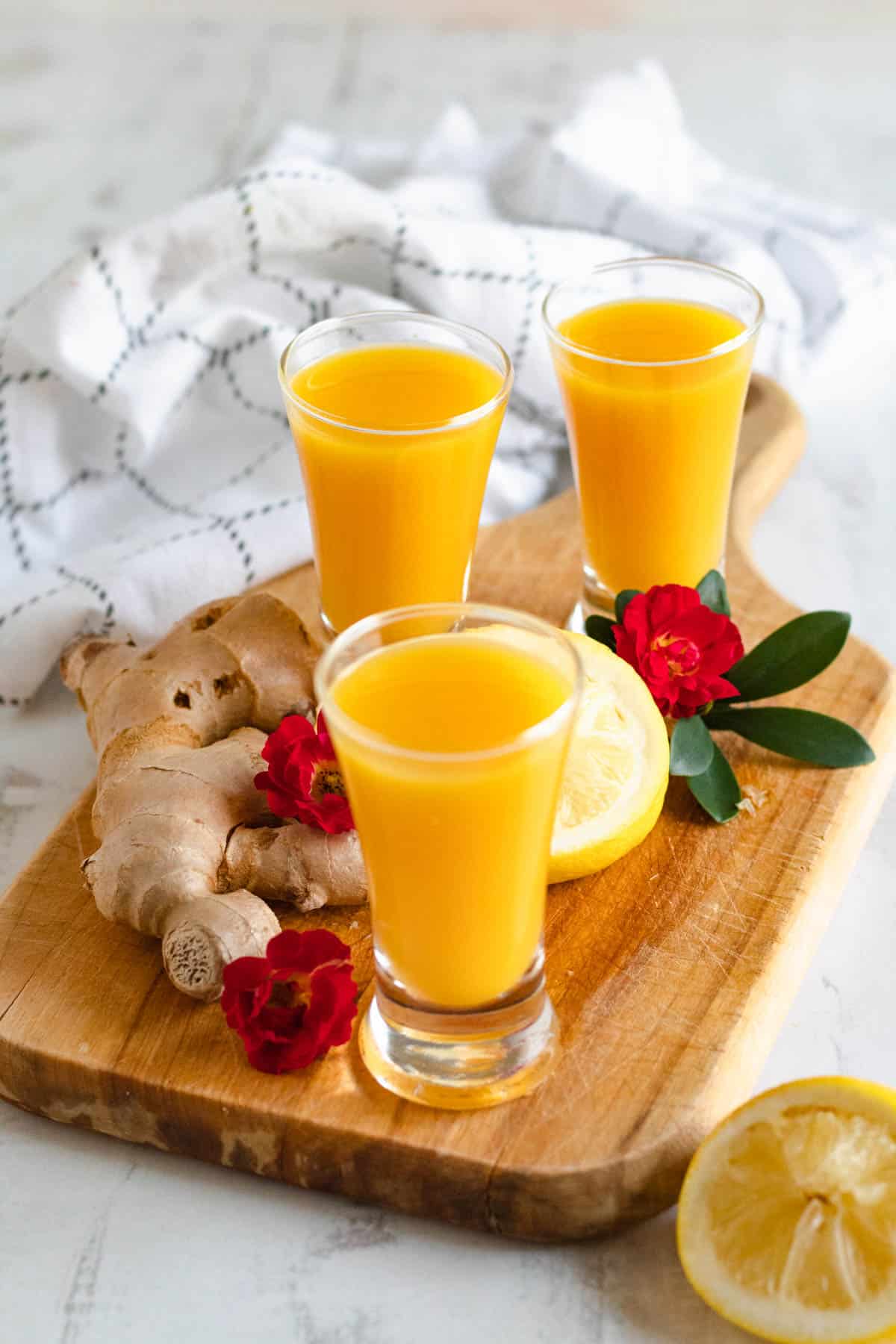ginger shot recipe in 3 shot glasses with a light colored background