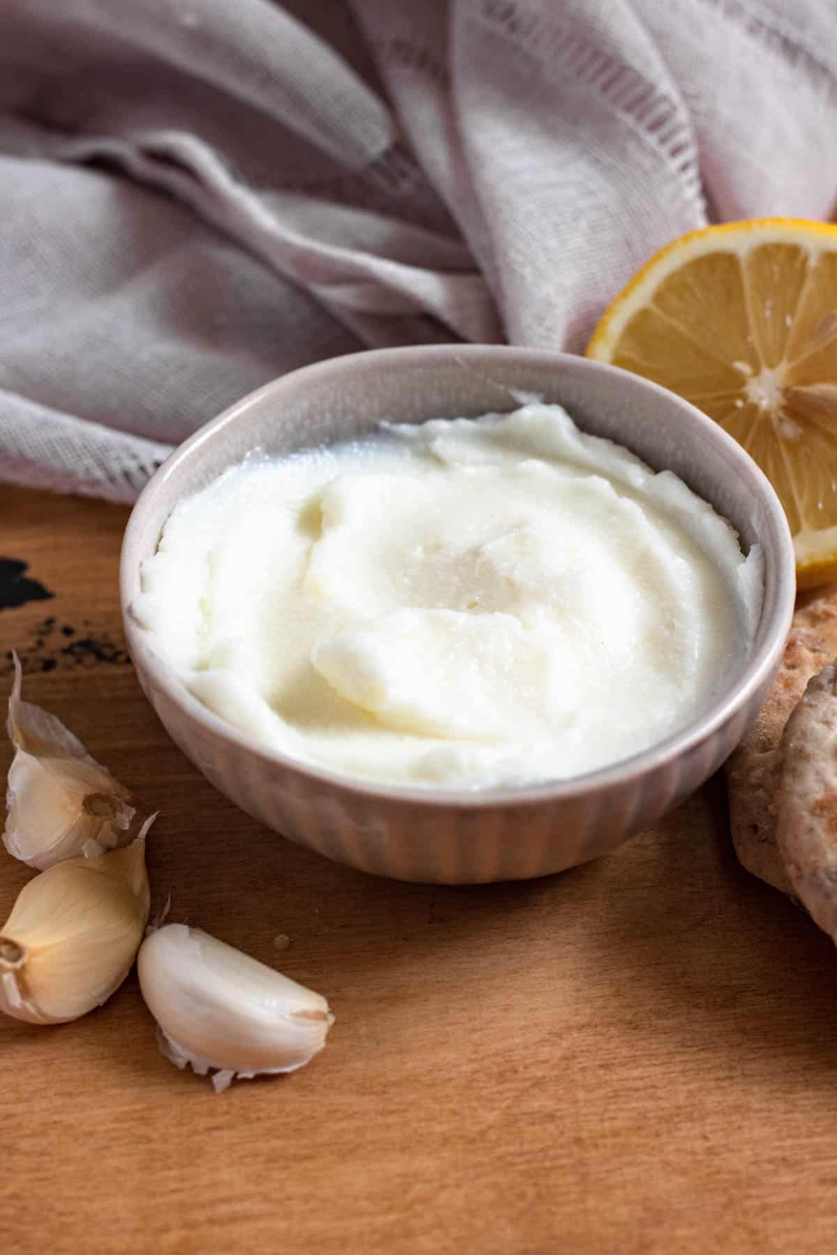homemade garlic sauce in a small bowl with a dark colored background