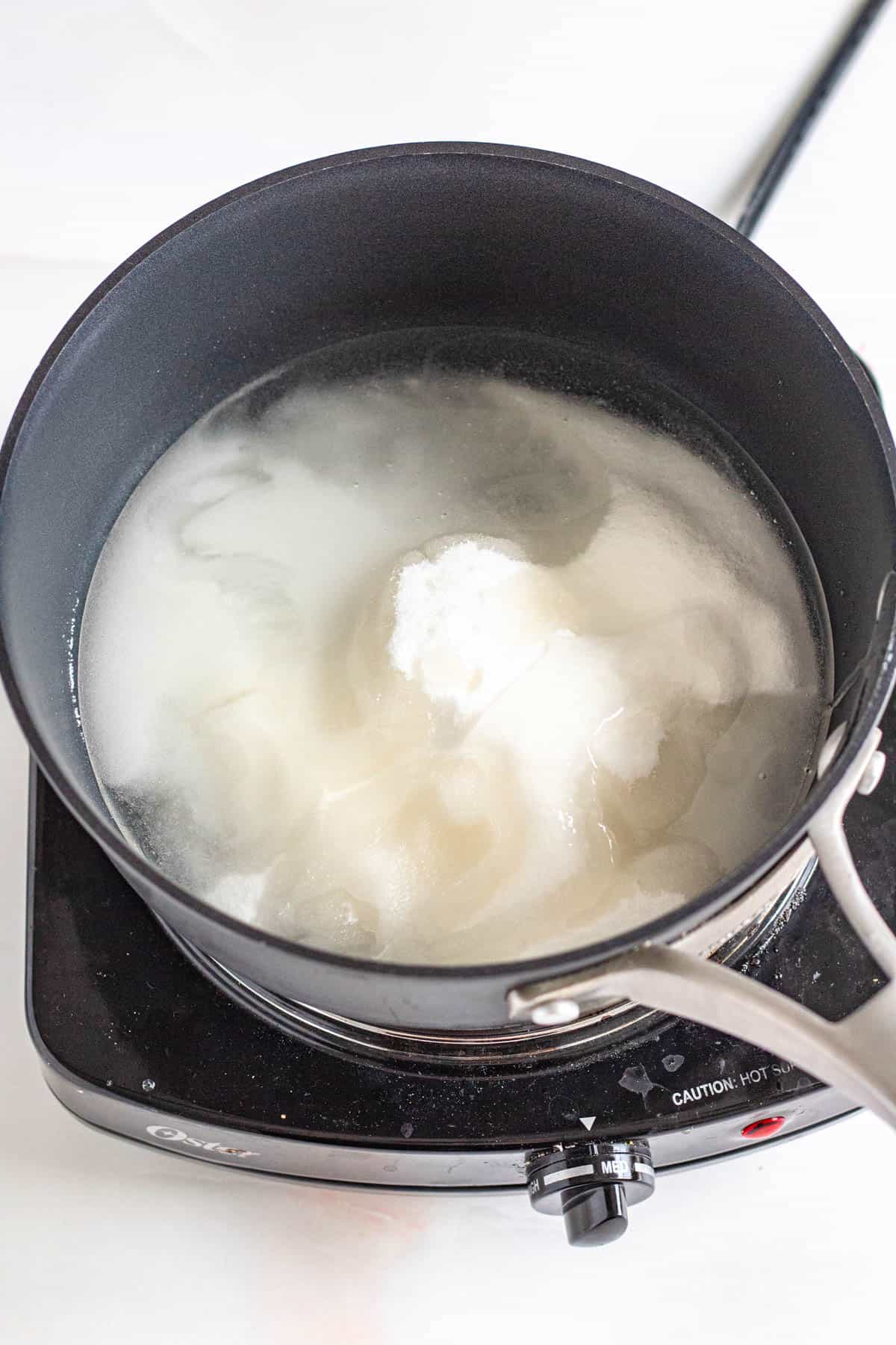 water and sugar in a pot ready to boil with a light colored background