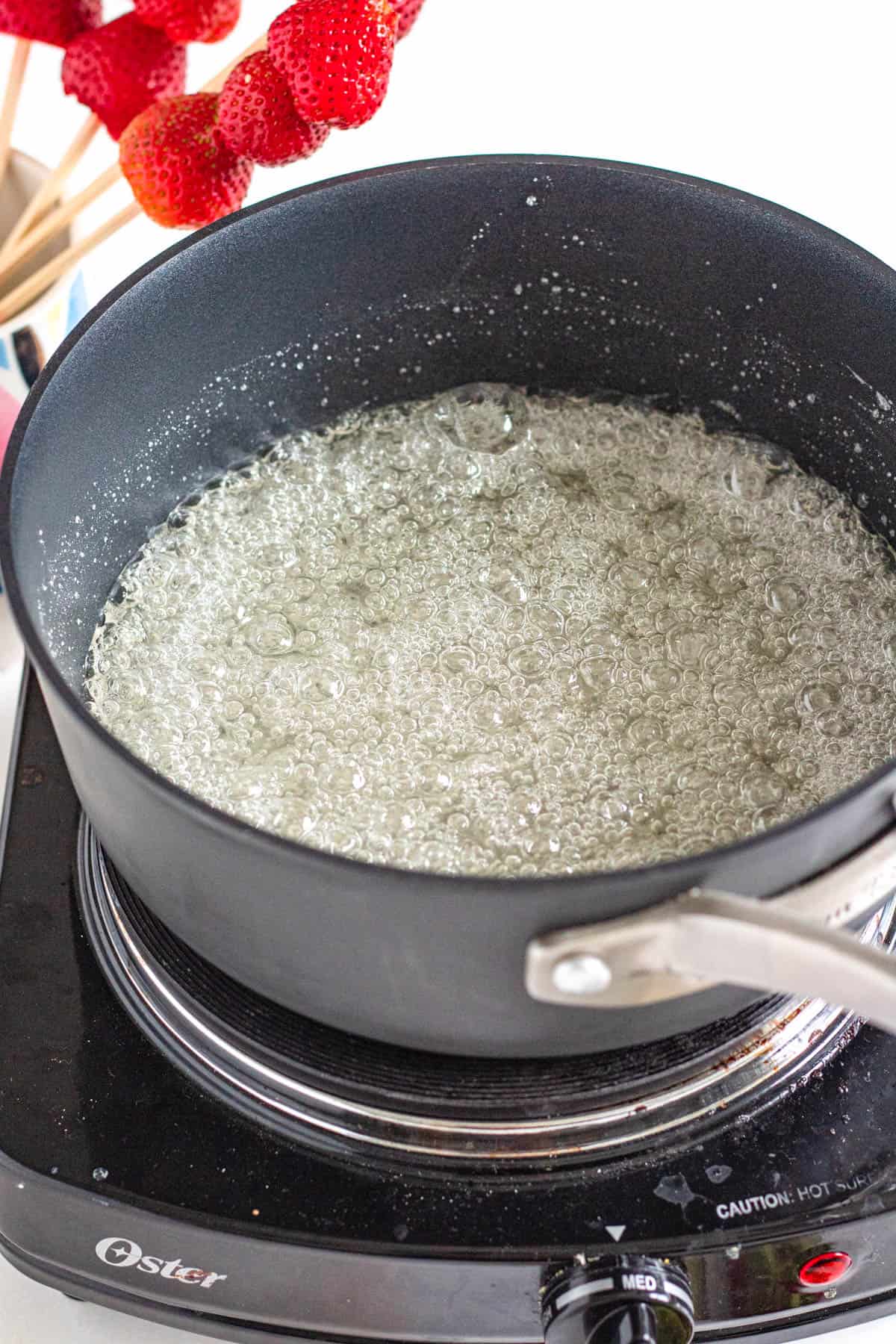 boiling water and sugar mixture in a pot with a light colored background
