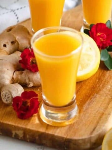 ginger shot recipe in 3 shot glasses with a light colored background