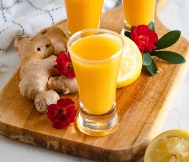 ginger shot recipe in 3 shot glasses with a light colored background
