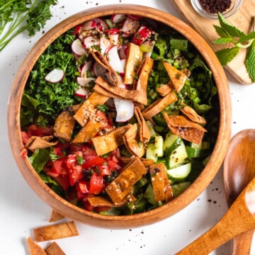 fattoush salad in a wooden bowl with a light colored background
