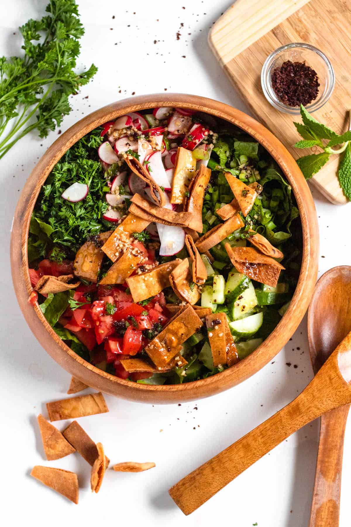 fattoush salad in a wooden bowl with a light colored background