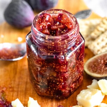 homemade fig jam in a small glass jar with a light colored background