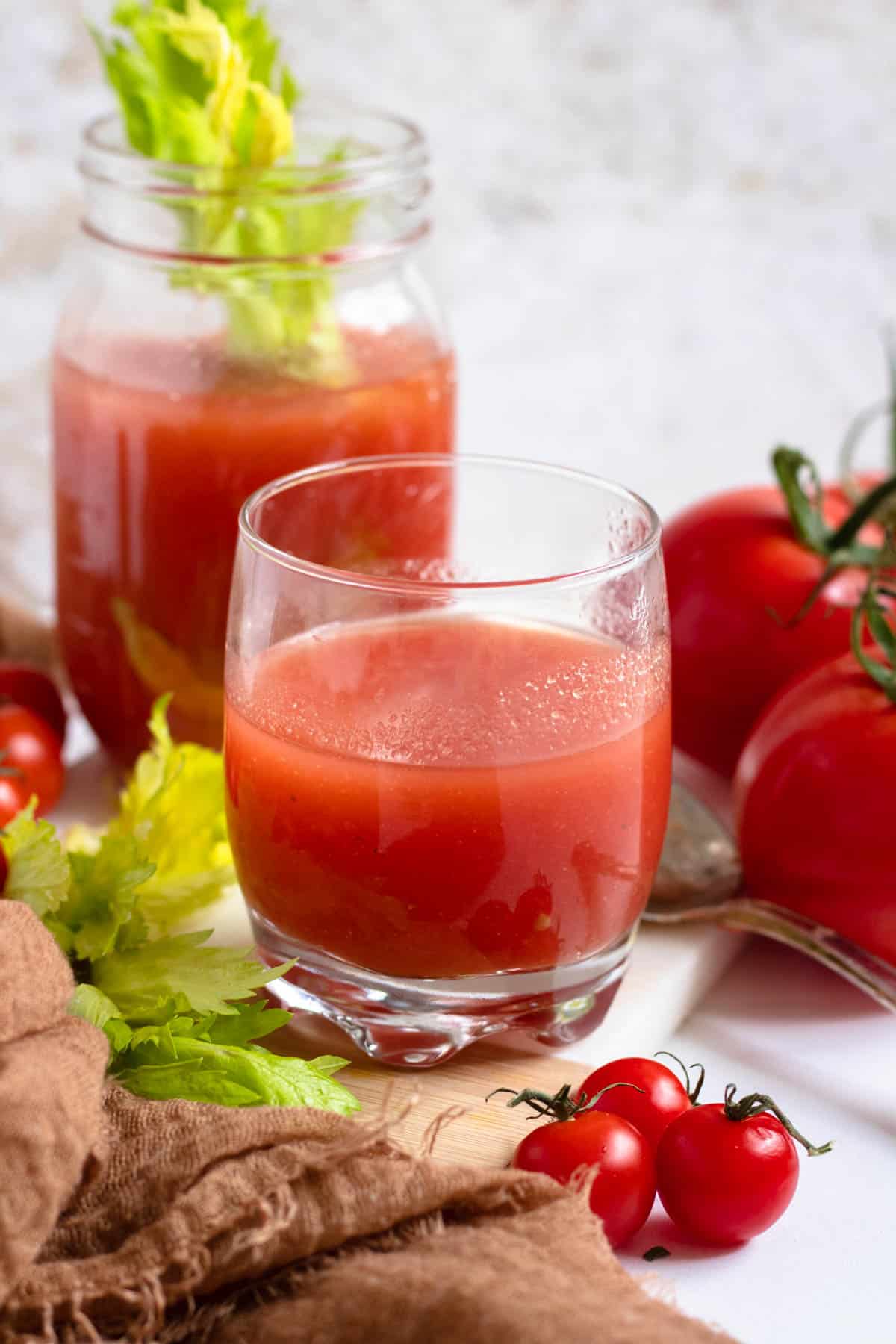 tomato juice in a small glass with a light colored background