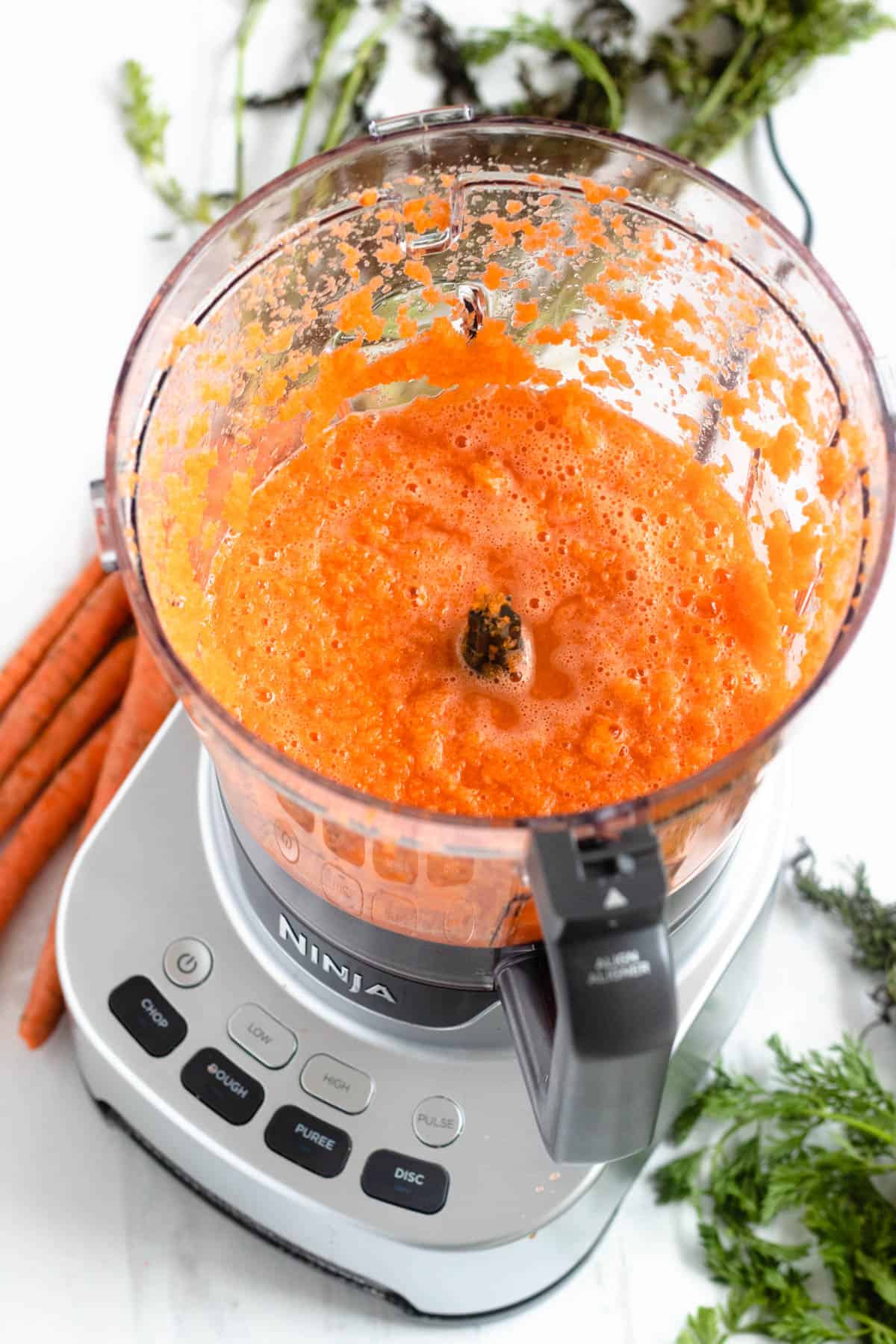 carrots and water blended in a food processor with a light colored background