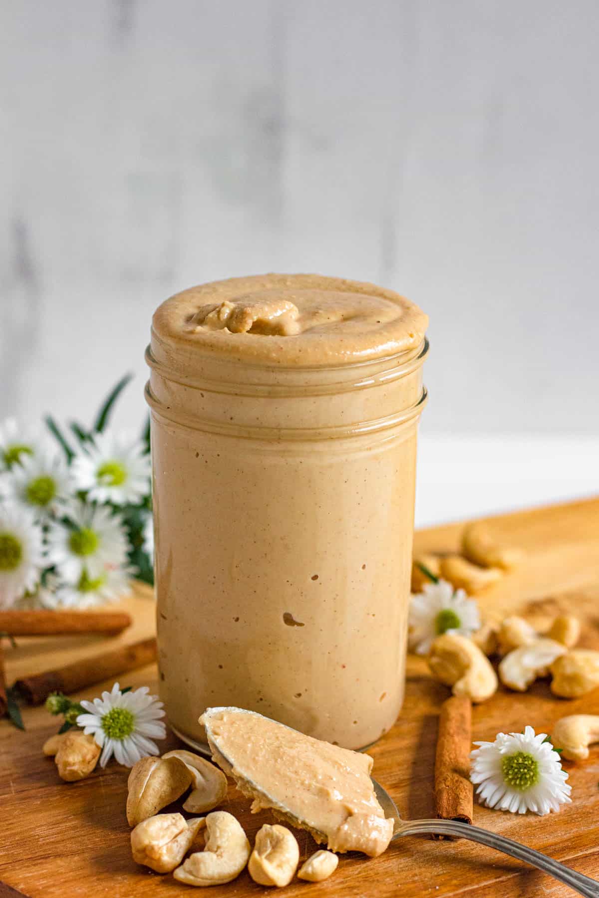 cashew butter in a glass jar with a light colored background
