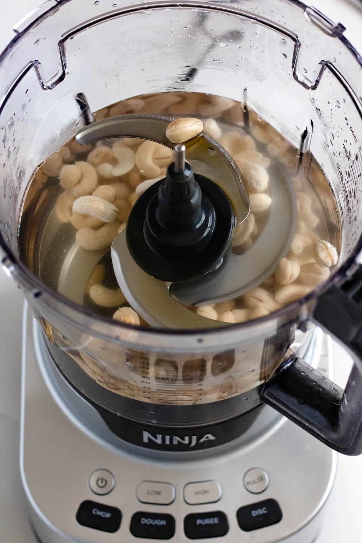 cashews, water, and maple syrup in a food processor 