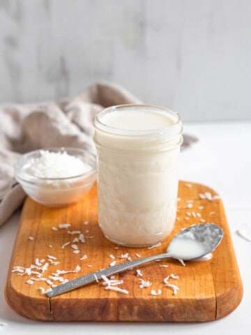 coconut butter in a small glass jar with a light colored background