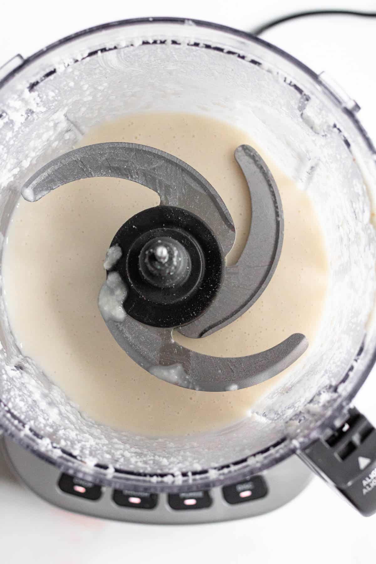 shredded coconut in a food processor forming a liquid 