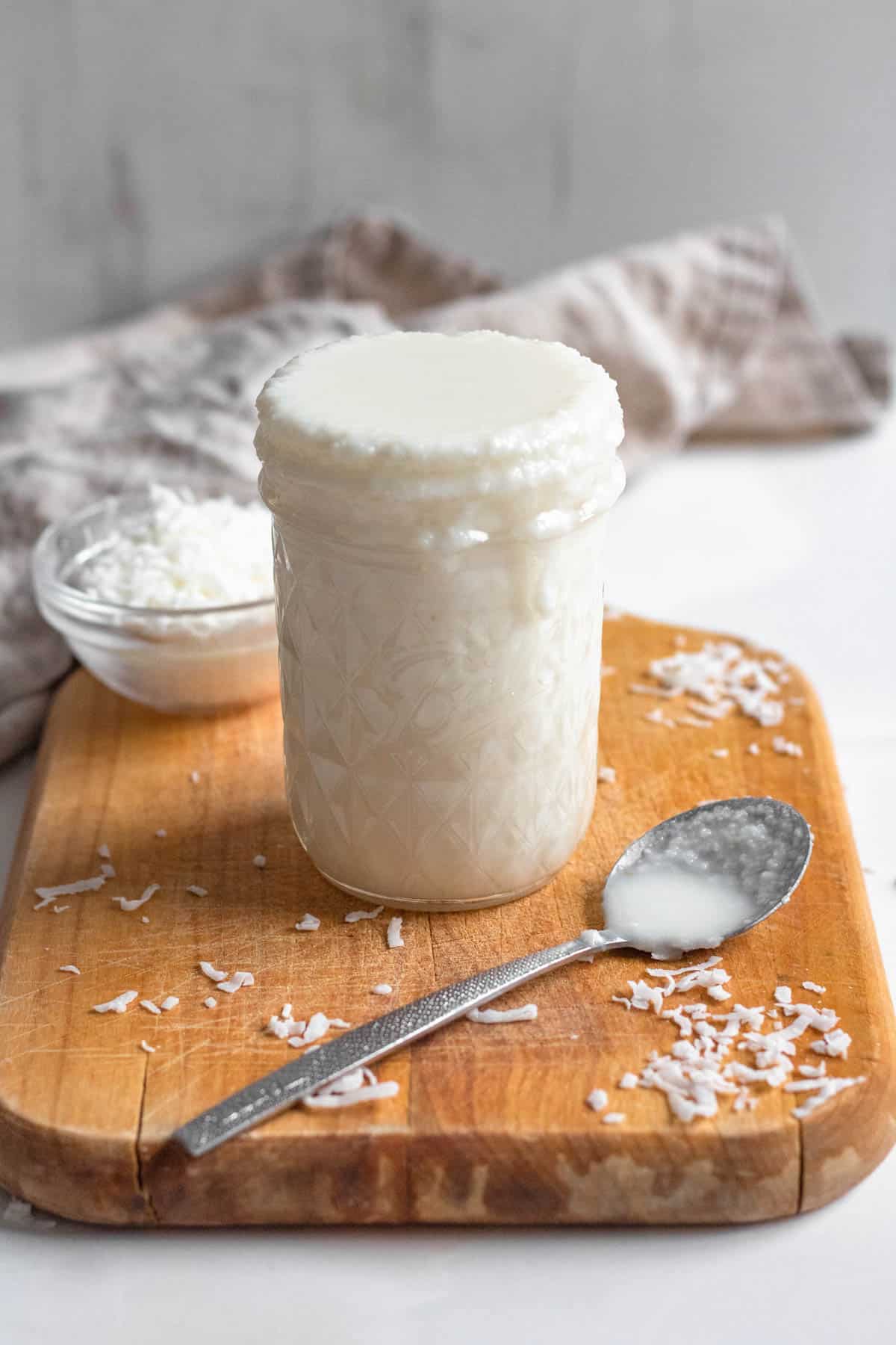 coconut butter in a small glass jar with a light colored background