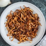 fried onions on a round white plate