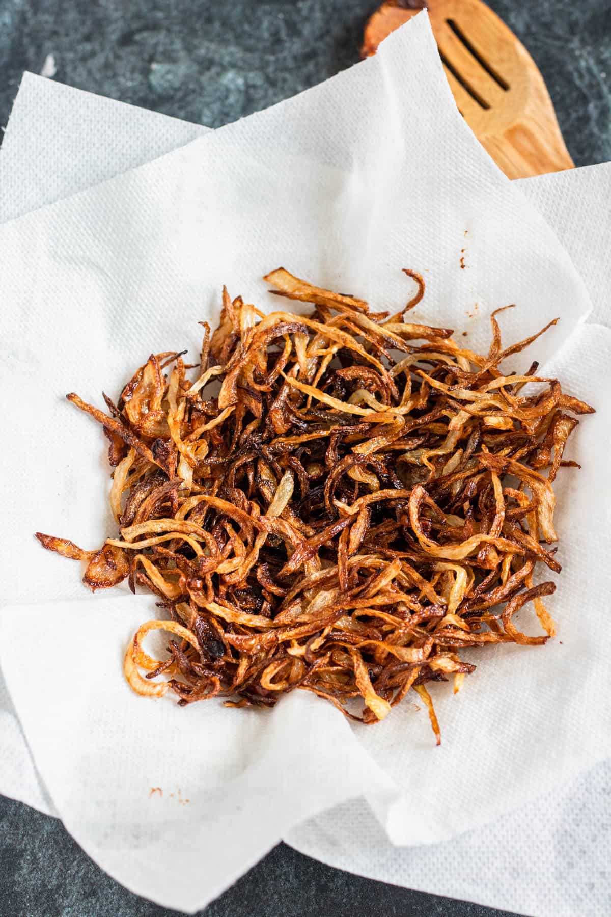fried onions on a paper towel-lined plate