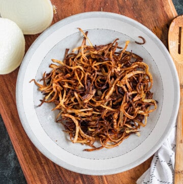 fried onions in a white bowl with a medium colored background